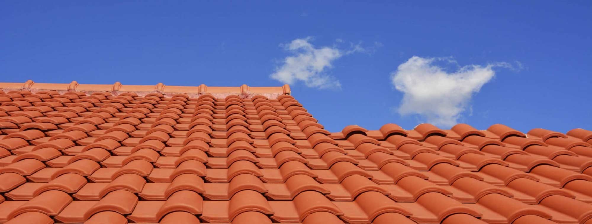 Toiture en gros plan, tuiles en terre cuite, ciel bleu